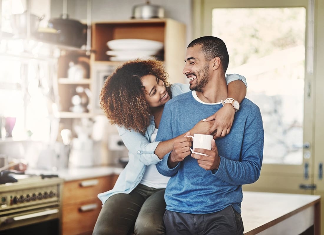 We Are Independent - Portrait of a Young Married Couple Spending Time Together in the Kitchen in the Morning While Holding a Cup of Coffee